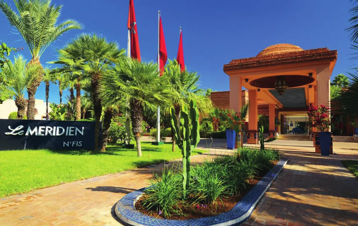 The entrance of Le Méridien N'Fis under its dome, among palms and cacti