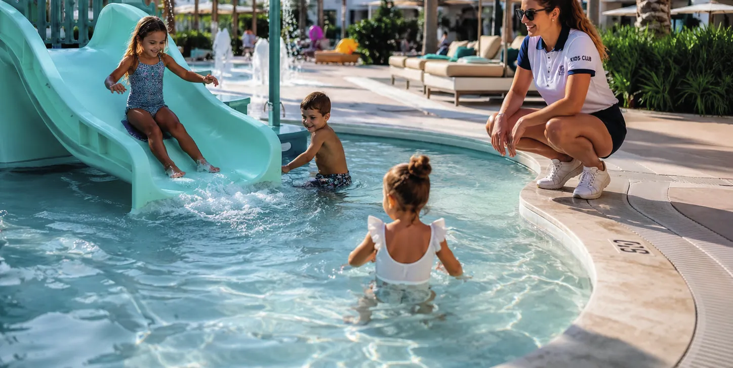 Children on the paddling pool slide, with a kids club instructor